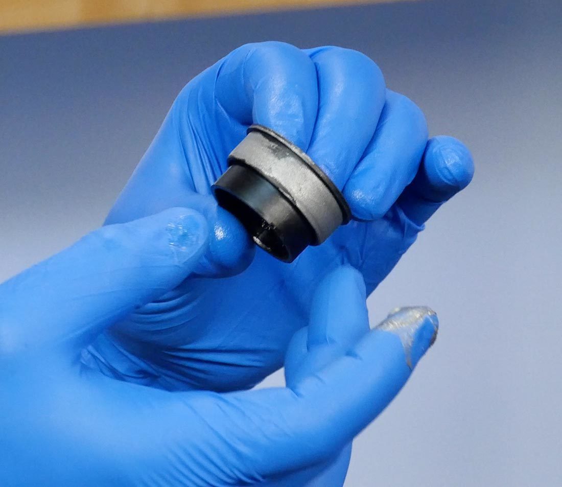 Press fit bottom bracket bearing cup held in hand with finger applying anti-seize to contact surfaces