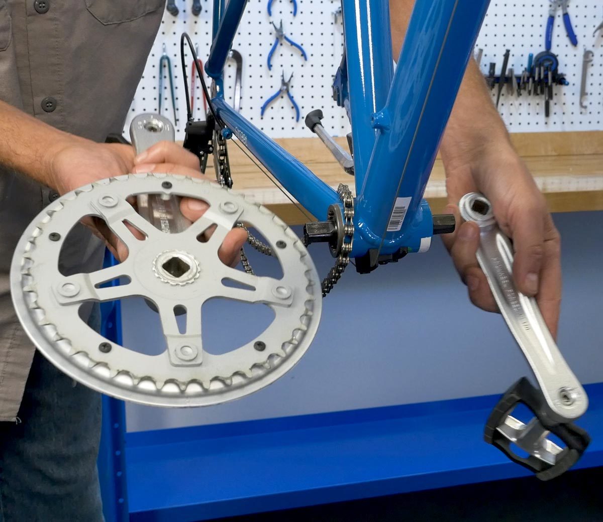 Drive side and non-drive side crank arms held next to bottom bracket shell on bicycle with three-piece system