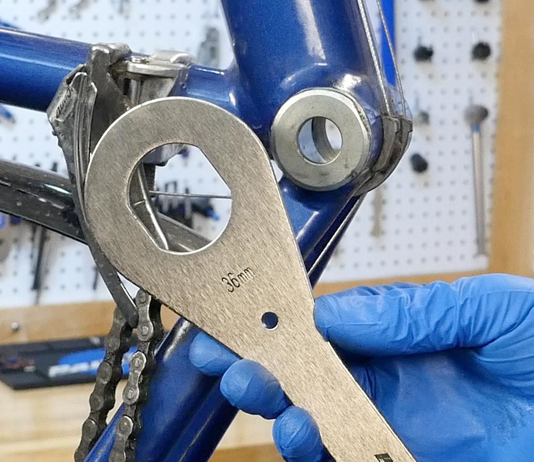 HCW-4 next to fixed cup in bottom bracket shell on blue bicycle frame