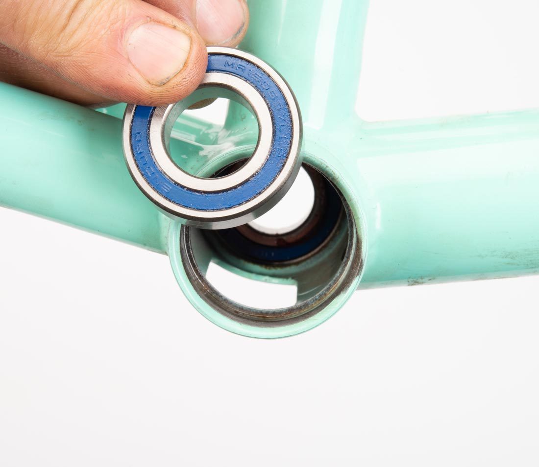 Spanish bottom bracket bearing held next to compatible bottom bracket shell of BMX frame