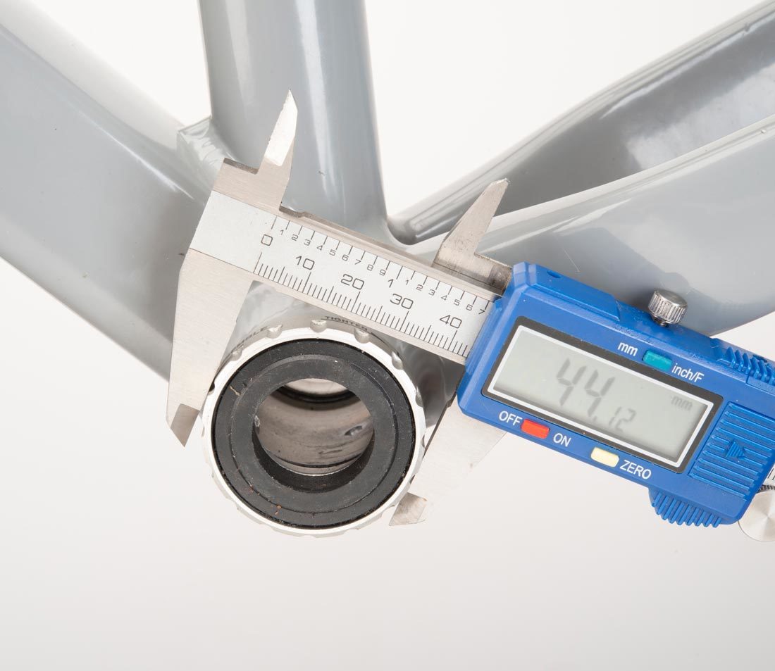 Digital caliper measuring outside diameter of external bottom bracket cup mounted to bottom bracket shell