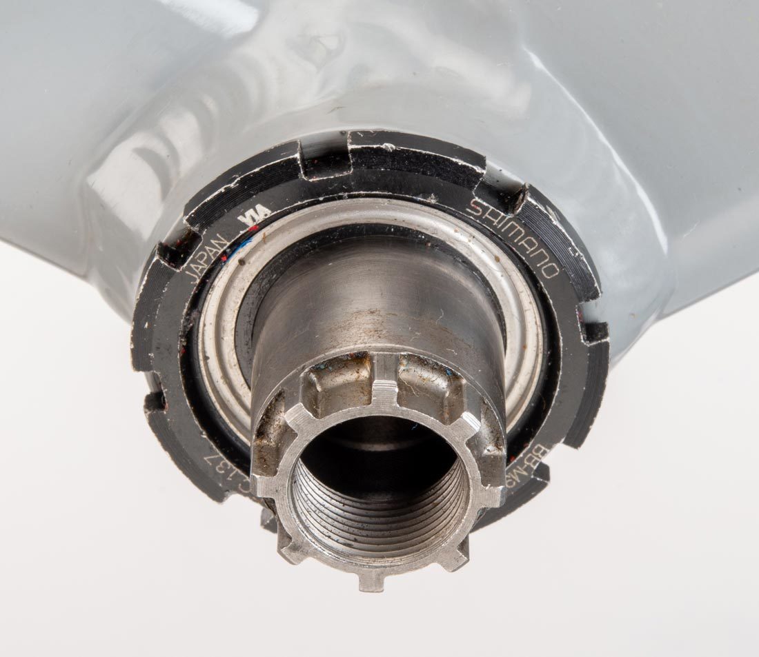 Cartridge bottom bracket with eight external notches, installed in bottom bracket shell on gray alloy frame