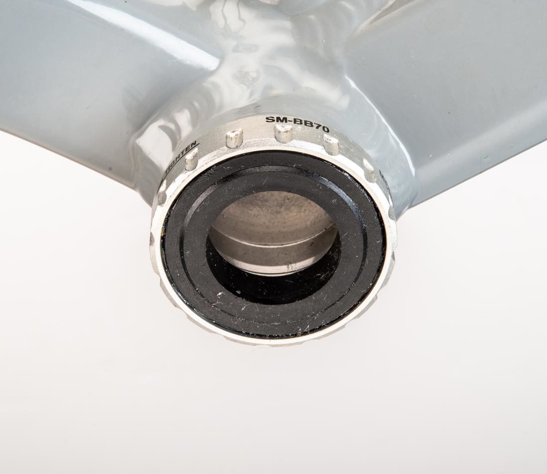 Threaded bottom bracket cup with 16 external notches, installed in bottom bracket shell on gray alloy frame