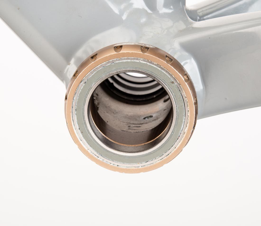Threaded bottom bracket cup with 16 external notches, installed in bottom bracket shell on gray alloy frame
