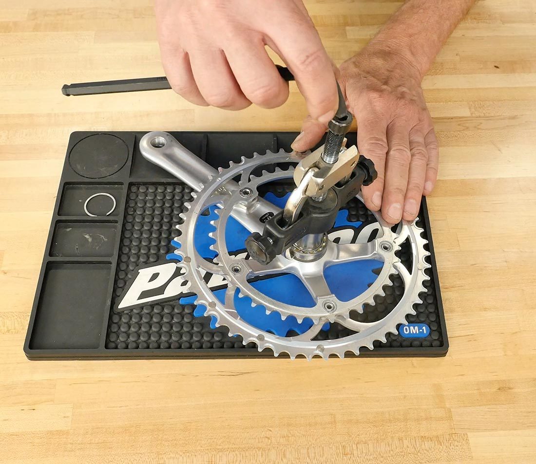 Hex wrench being installed onto CBP-8 caliper driver with prongs secured underneath bearing on crank spindle