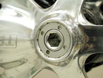 Self-extracting system with pin holes in retaining cap