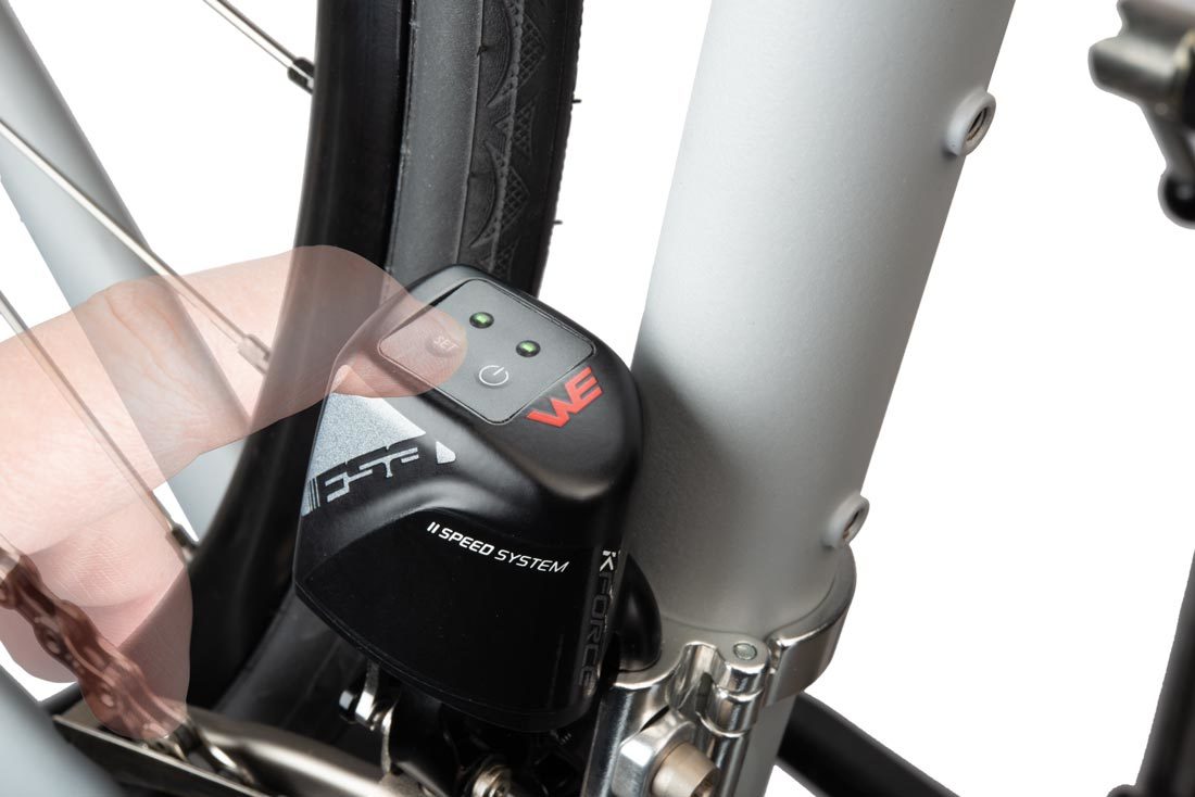 Finger pressing the set button on WE® front derailleur mounted to bicycle