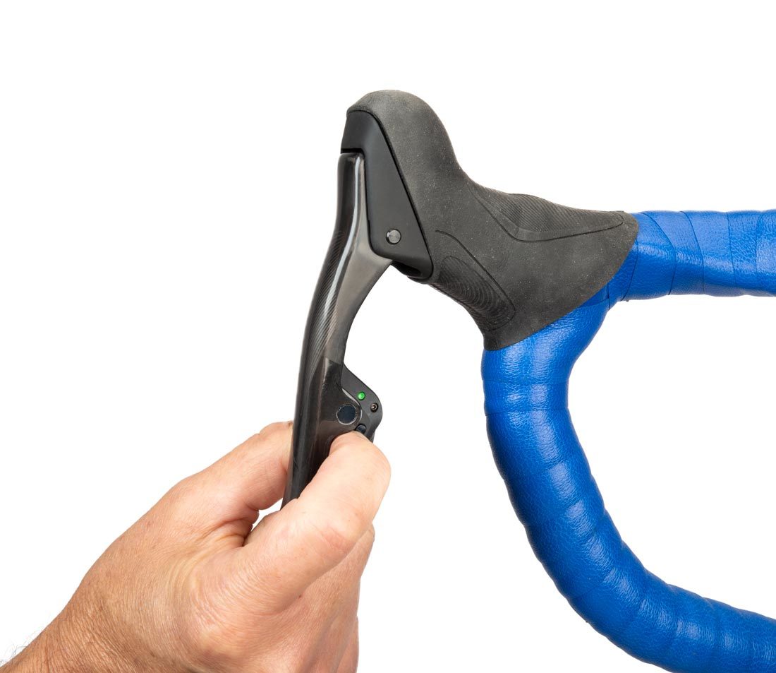 Finger pressing button on AXS® brake/shift lever mounted on drop handlebars