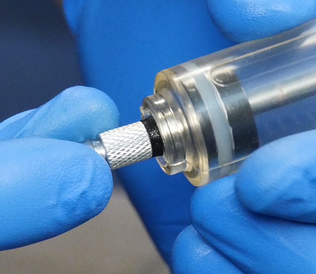 Hose being finger threaded into brake bleeding syringe