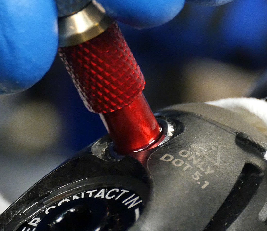 Adaptor end of syringe hose being installed into brake lever bleed port