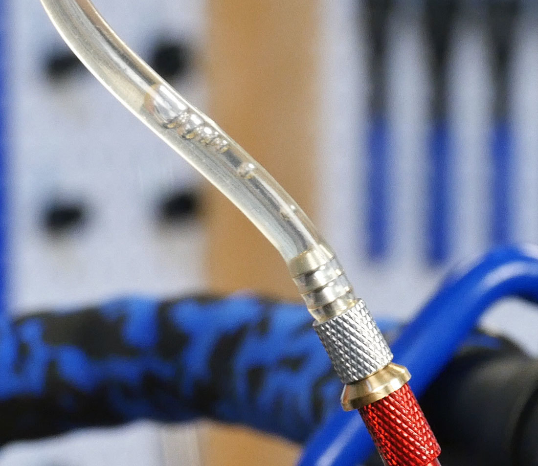 Air bubbles leaving braking system through syringe hose end at brake lever