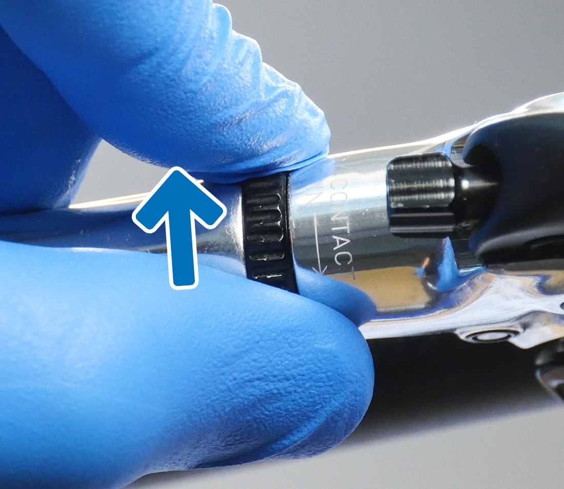 Closeup of brake lever contact adjuster being turned counterclockwise by hand