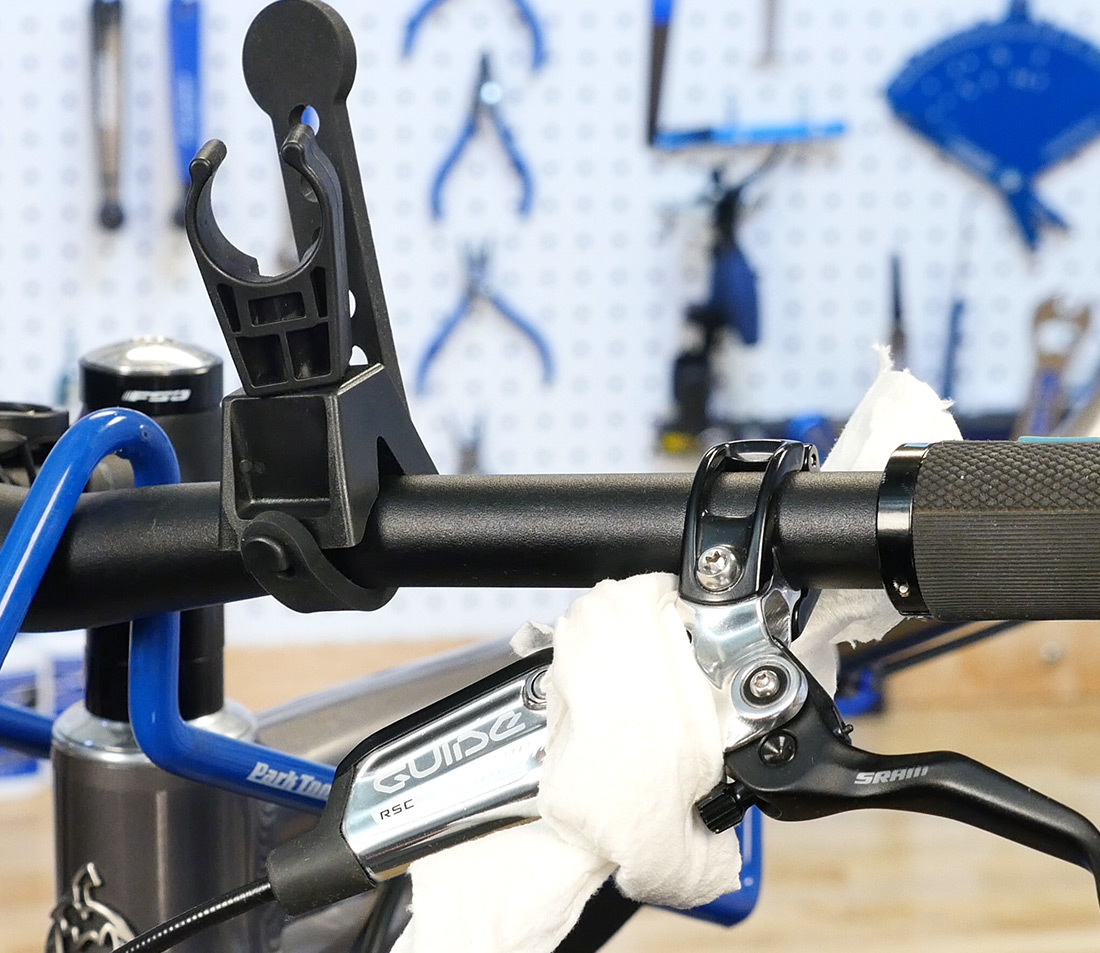 Brake lever on flat handlebars prepped with syringe holder and rag