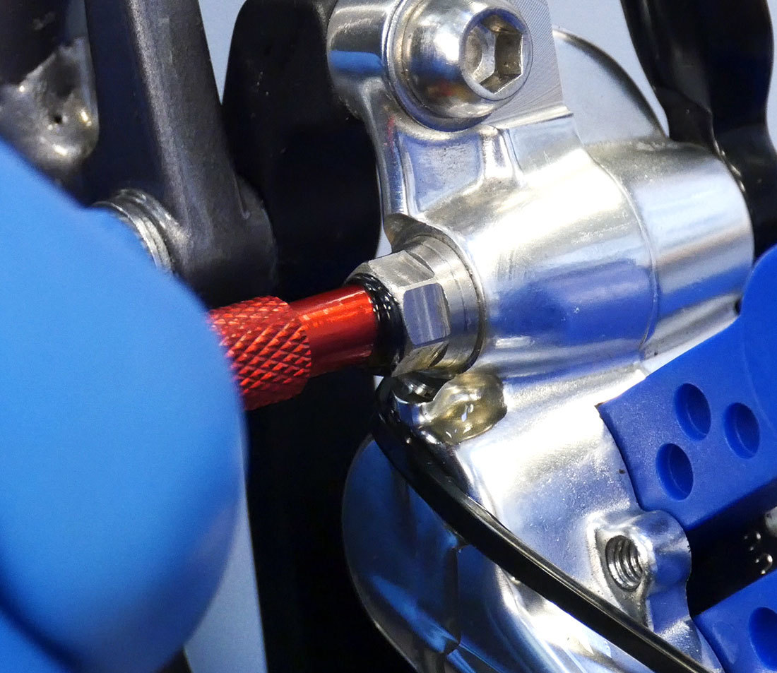 Adaptor end of bleed syringe being installed into bleed port of brake caliper