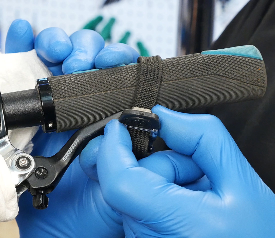 Toe strap being secured around brake lever and flat handlebar to hold lever in place