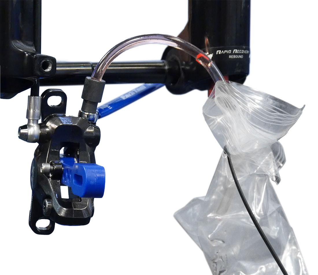 Install the open hose with plastic bag on the caliper bleed port
