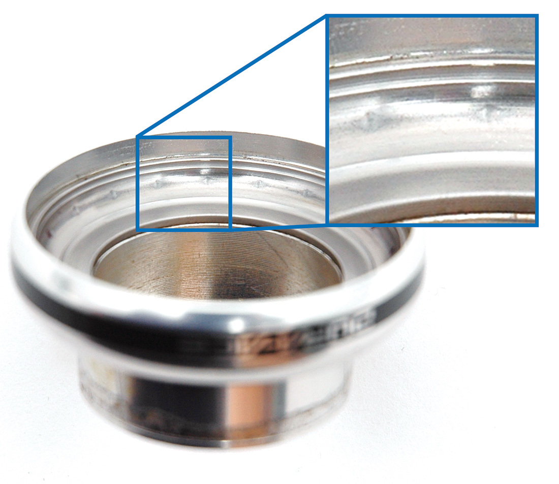 Headset cup with pits indicating wear from ball bearings