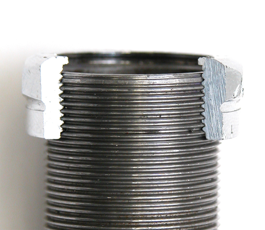 Cutaway of locknut on threaded steering column. The lip of the locknut should not contact the top of column.