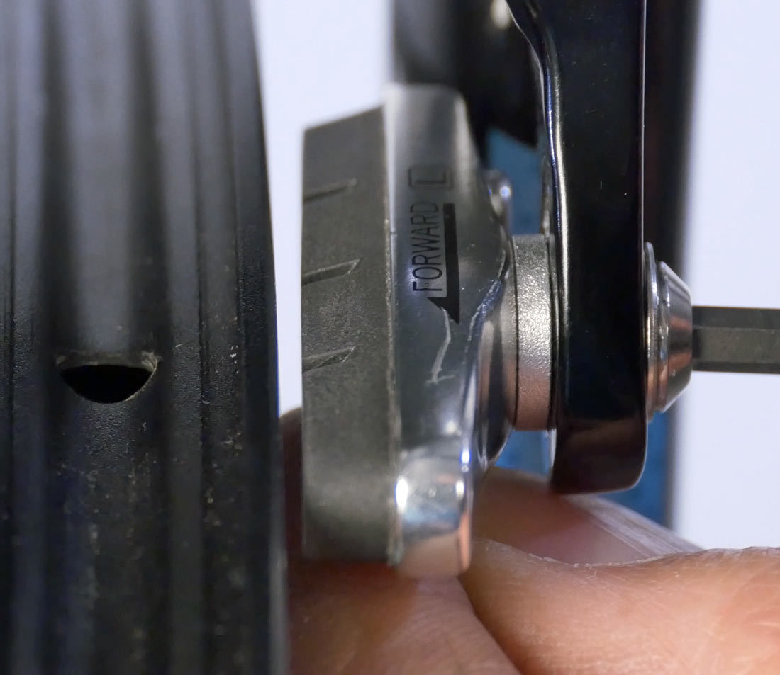 Hold pad with trailing edge outward and secure brake bolt/nut