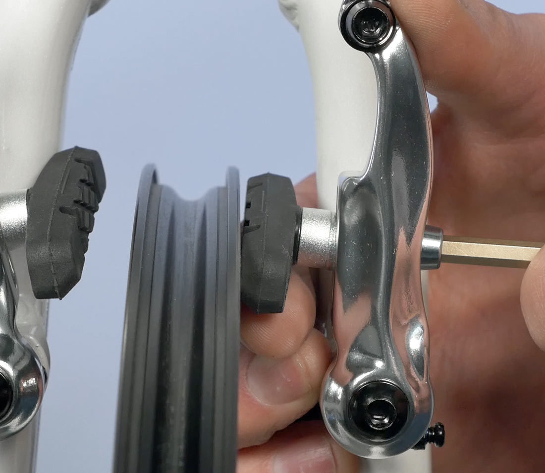 Manipulate washers so front of pad strikes rim first for brake toe