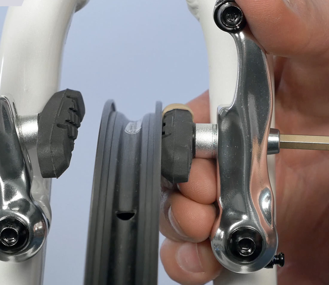 A rubber band shim at back end of pad to create gap or toe