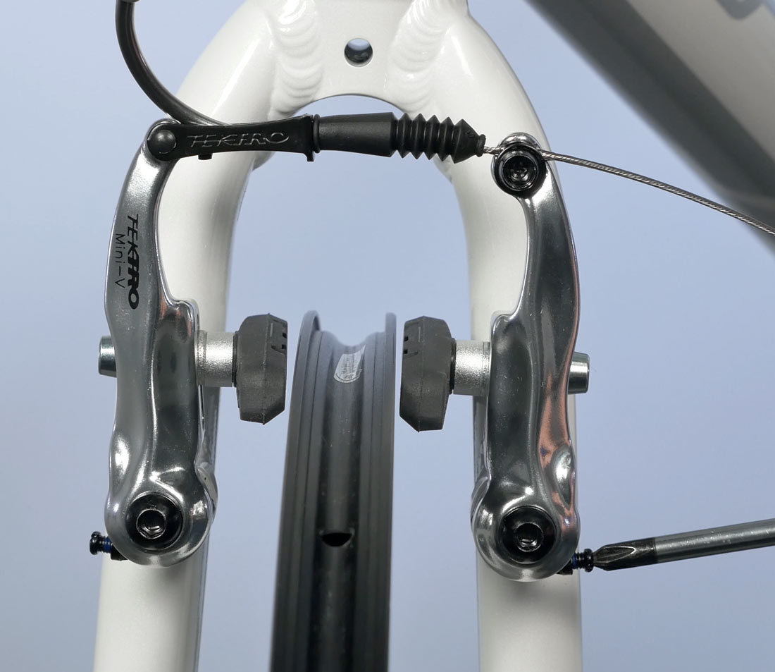Use centering screw to move arms and center pads to rim