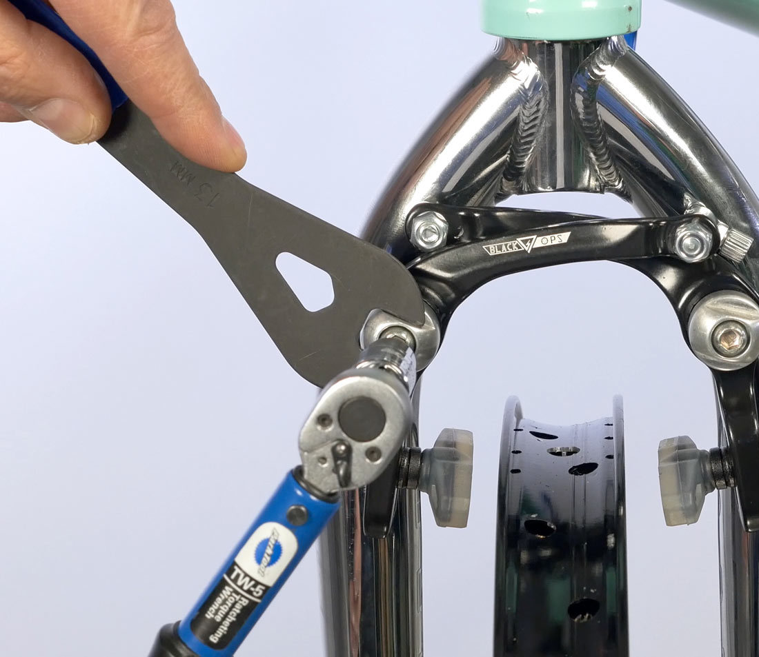 Hold brake fitting with cone wrench and secure mounting bolt