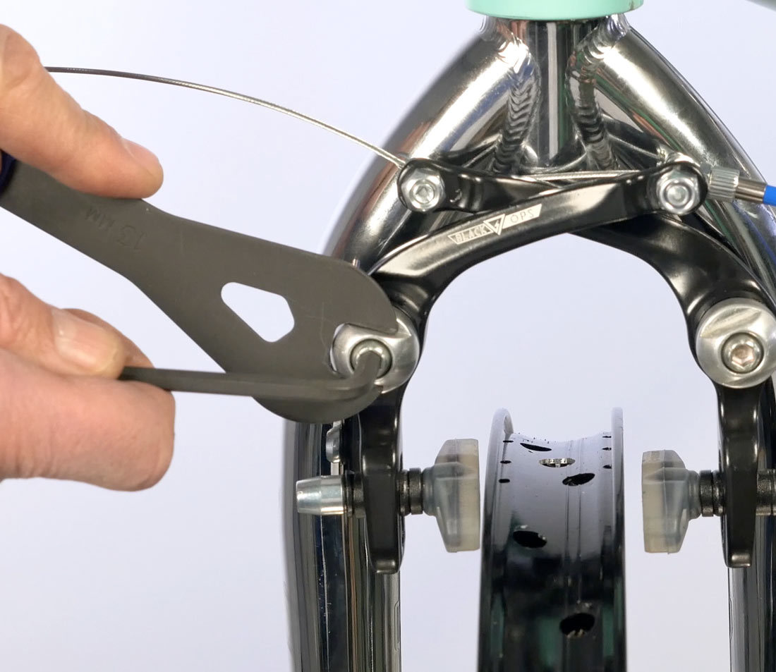 Add spring tension to pad that is closer to the rim