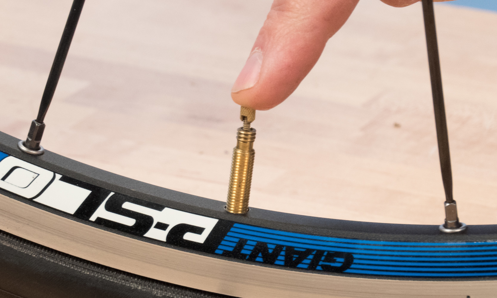 To deflate a Presta valve, unthread the locknut at the tip of the valve stem and press