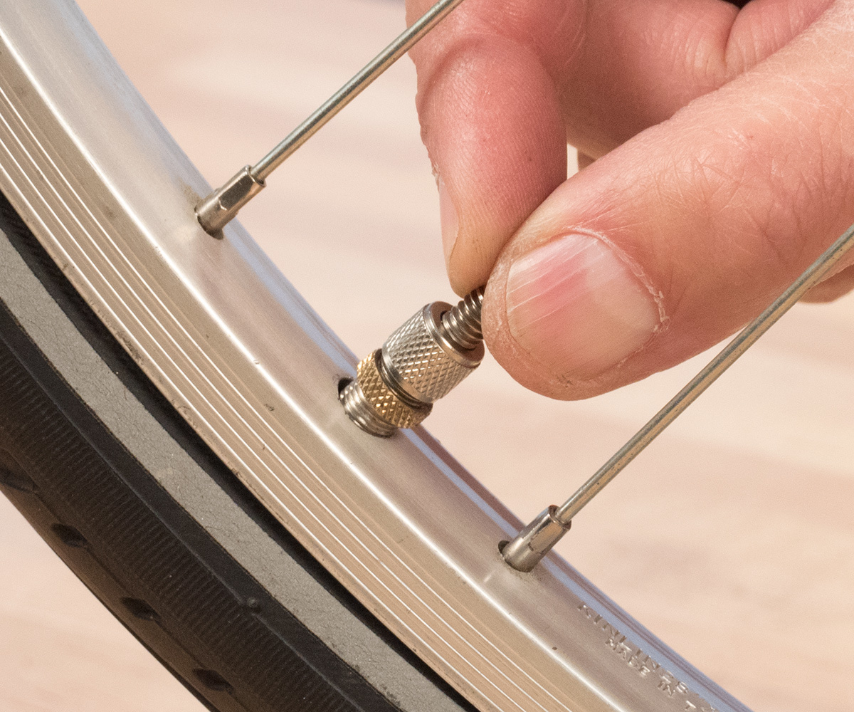 On a Dunlop valve, unthread the cap a few turns, then pull outward on the tip of the valve