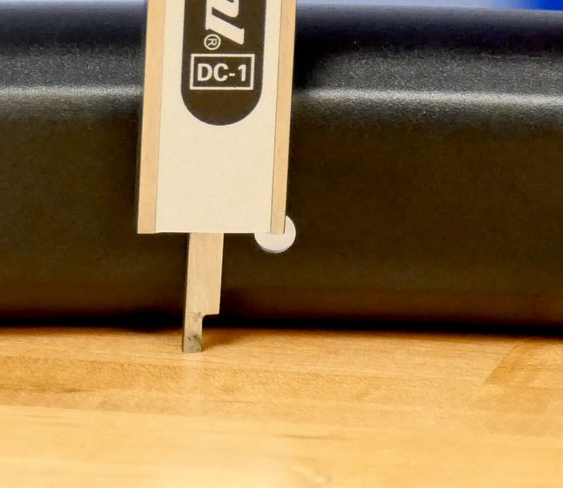 Rod of digital caliper extended and resting on table with end aligned with rim center