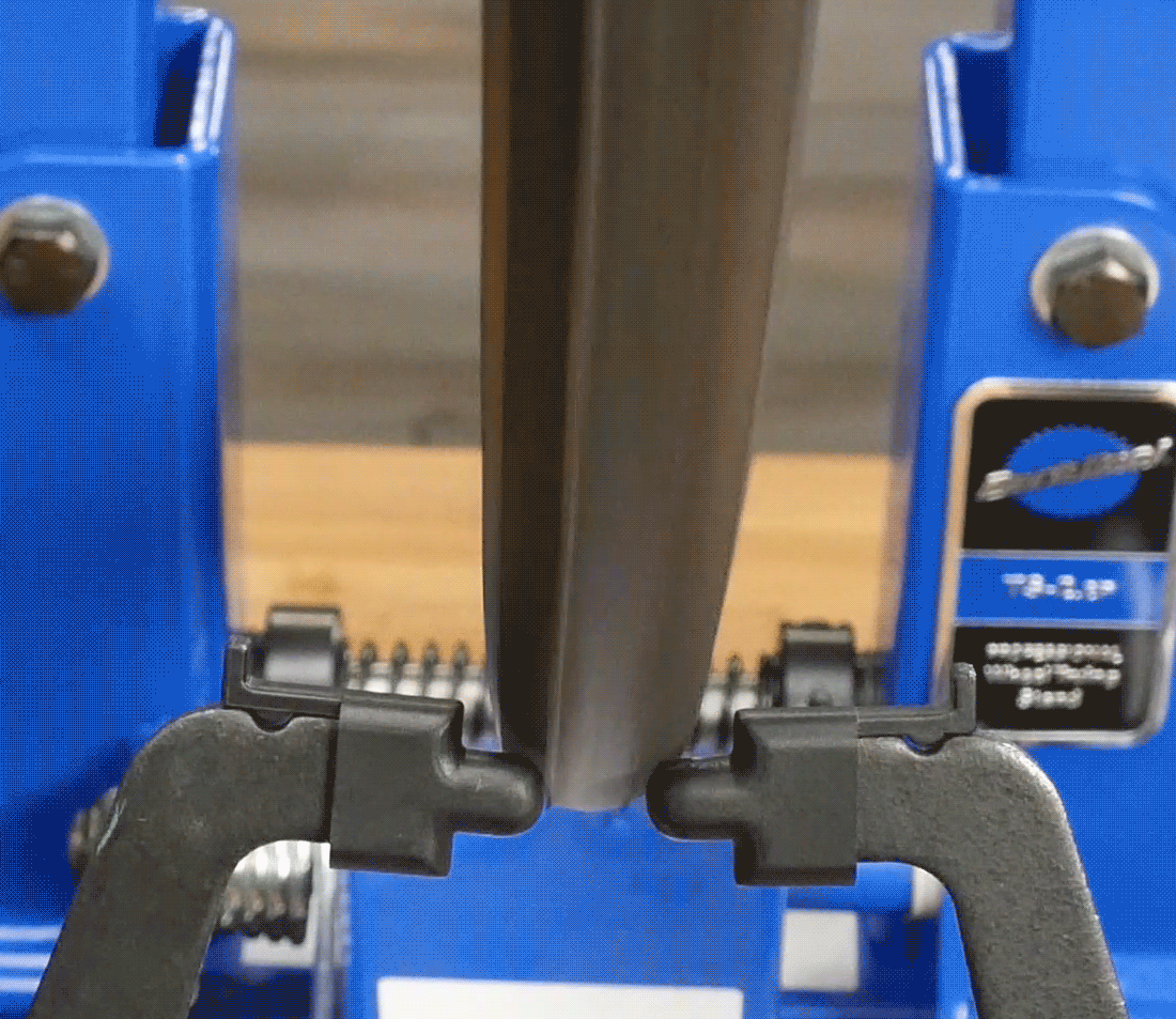 Wheel with tire installed spinning in truing stand