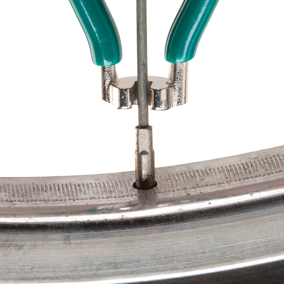 Green SW-1 spoke wrench being fitted to square spoke nipple on wheel
