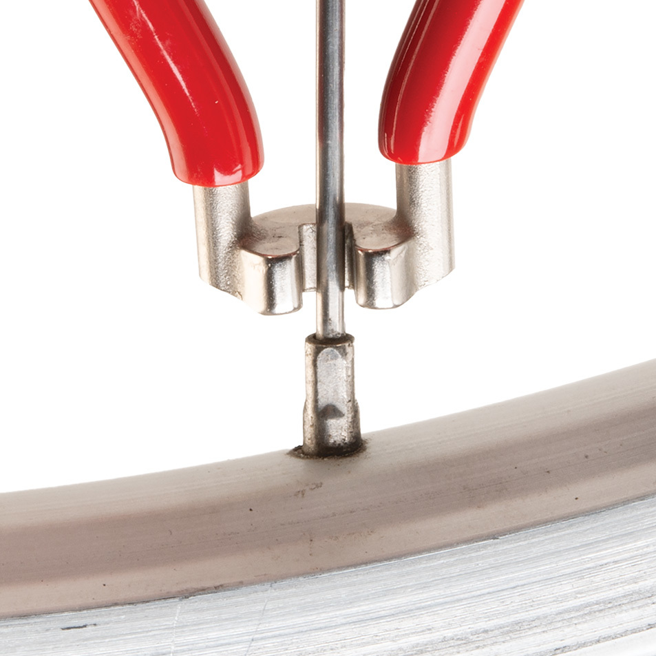 Red SW-2 spoke wrench being fitted to square spoke nipple on wheel